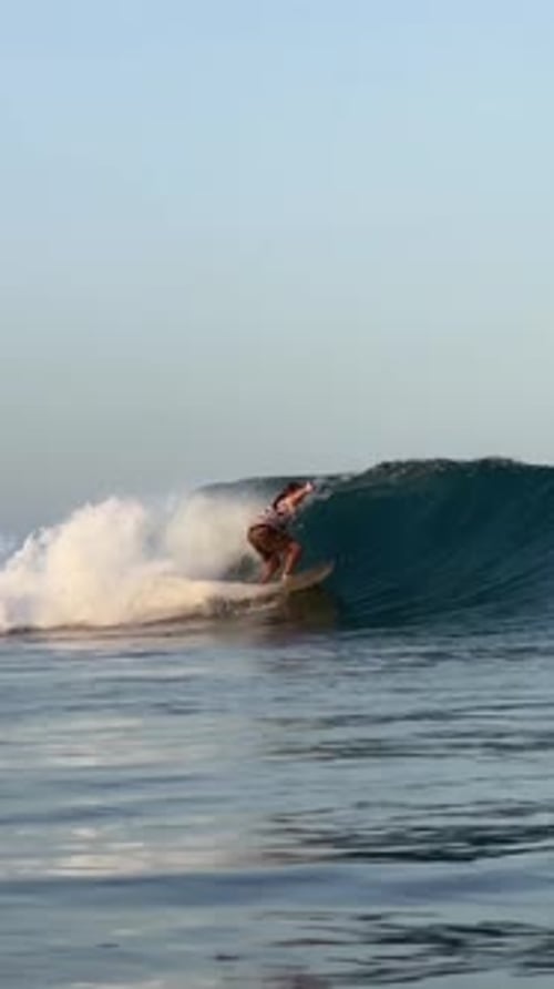 Young Guy Surfs in the Ocean