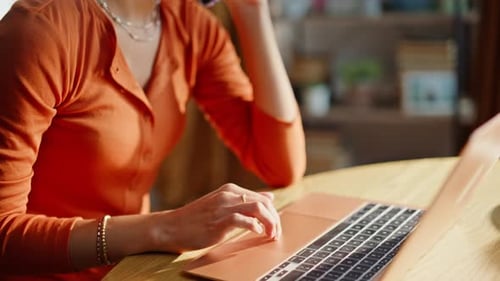 Woman Working on Laptop and Talking on Phone