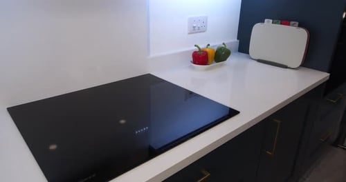 Woman Places Pot on Modern Electric Stove Top