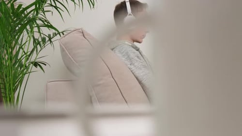 Young Adult Using Laptop and Headphones at Home