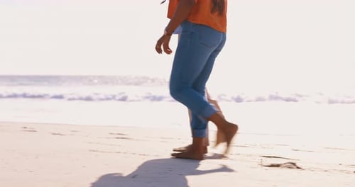 Legs, sunset and a couple walking on the beach together with their feet in the sand