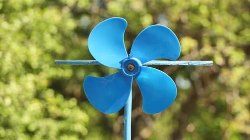 Une girouette bleue tourne dans le vent en été