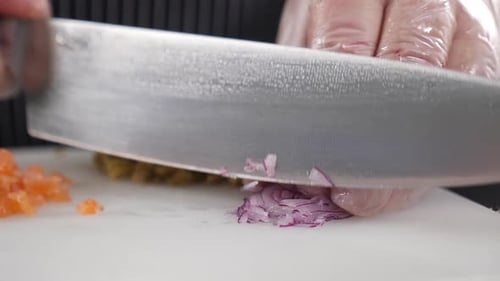 Chef Hands Dicing Onion with Knife on Board