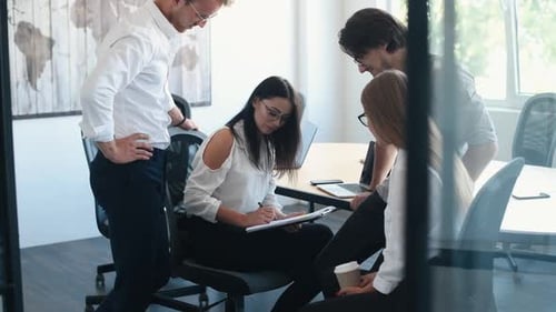 Woman signing document. Young business people in formal clothes working in the office