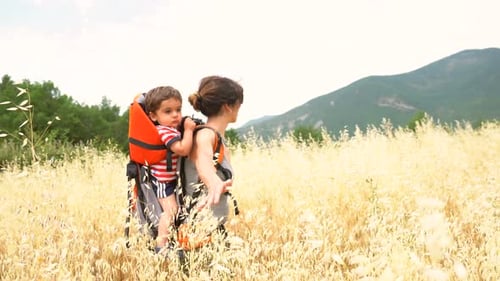 A woman with her son in a field of yellow wheat grain ready for harvest, summer vacation