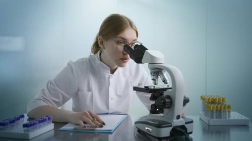 Young Woman Scientist Working With Microscope