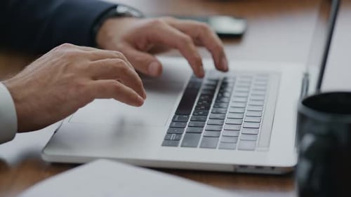 Menschenhände verwenden Touchpad auf Laptop beim Tippen von Dokumenten im Firmenbüro aus nächster Nähe
