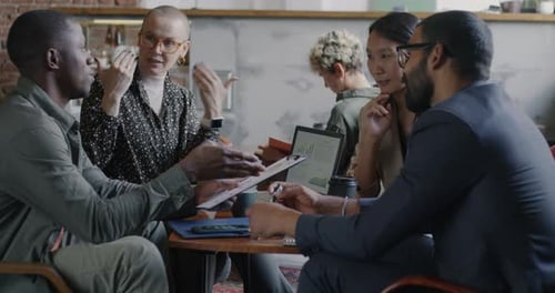 Creative Businesspeople Colleagues Discussing Work Talking and Looking at Laptop Screen in Office