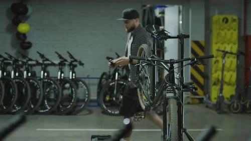 Mechanic Applying Lube to Chain on Bicycle in Garage