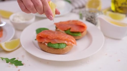 Squeezing Lemon on Salmon and Spinach Sandwiches