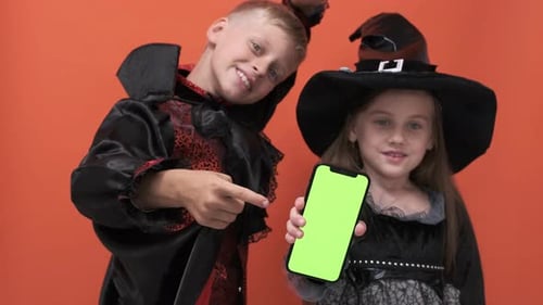 Kids in Halloween Costumes Holding Green Screen Phone