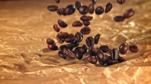 Kaffeebohnen fallen auf altes Papier, gefilmt mit einer Hochgeschwindigkeitskamera mit 1000 Bildern pro Sekunde