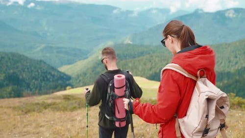 Couple Hiking With Backpacks in the Mountains