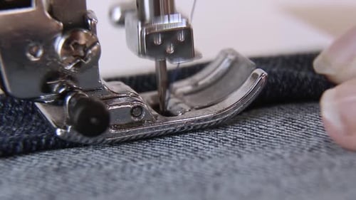 A Closeup Sewing Machine Sews Blue Denim