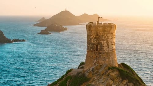 Exploring the ancient tower on a coastal cliff at sunset