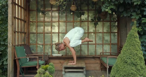 Woman Practicing Yoga Arm Balance Outdoors