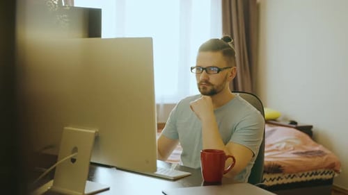 Man working at computer at home desk