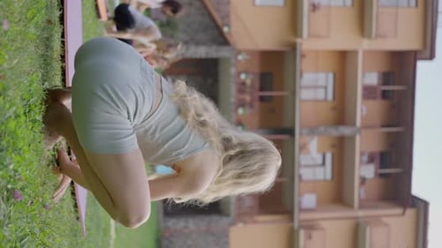 Young Adults Practice Yoga Outdoors on Grassy Field