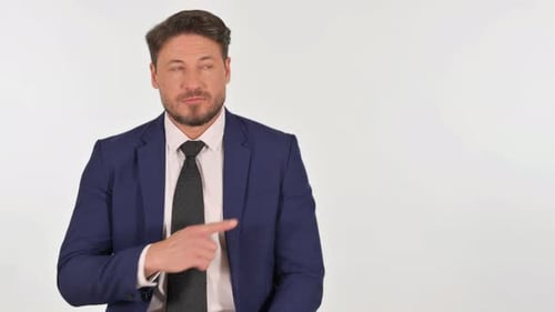 Man in Suit Points to Side on White Background