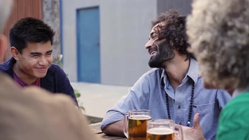 Friends Talking Over Beers at an Outdoor Table
