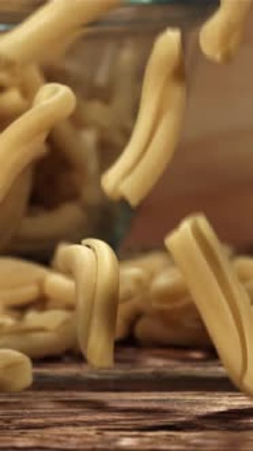 Dry Pasta Falls on a Wooden Table Filmed on a Highspeed Camera at 1000 Fps