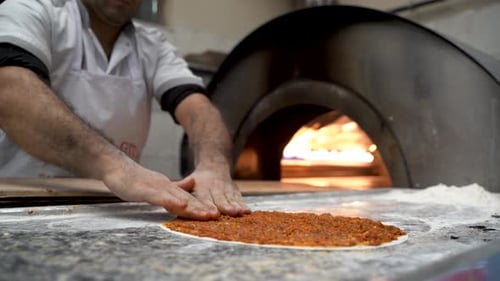 Chef of bakery making a Turkish pizza or lahmacun 4K