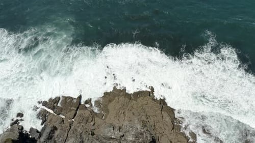 Foamy White Waves Crashing On Rocky Coastline At Summer. - aerial