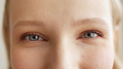 Close up of blonde woman face opening her beautiful blue eyes looking feel