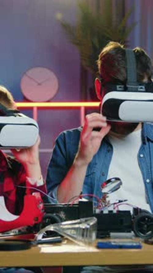 Boy and Man Building a Car with VR Headsets