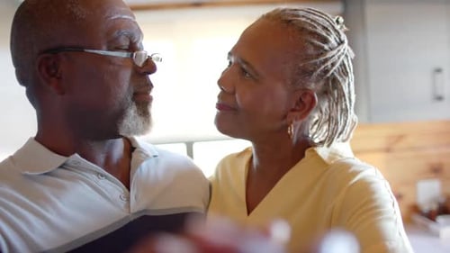 Loving Senior Couple Holding Hands at Home