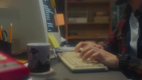 Young Adult Typing Code on Old Computer