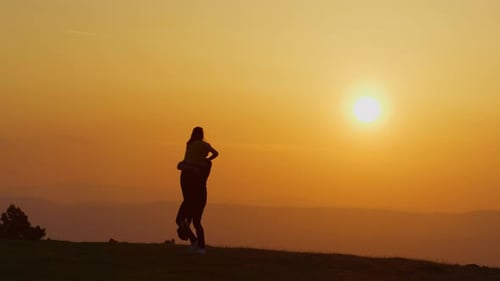 Couple Silhouetted Embracing at Sunset