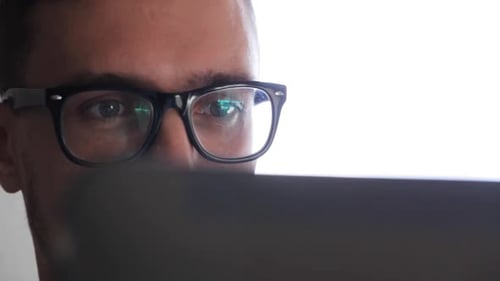 Close up of Man with Glasses Using Laptop