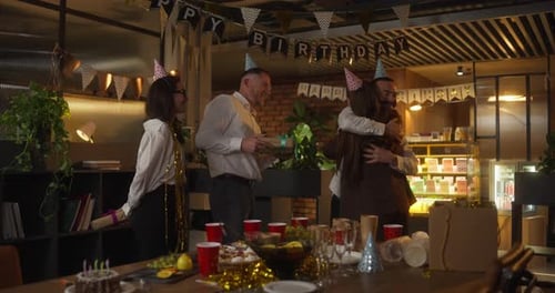 A Group of Office Workers Line Up and Give Gifts to a Girl in Business Clothes During a Corporate