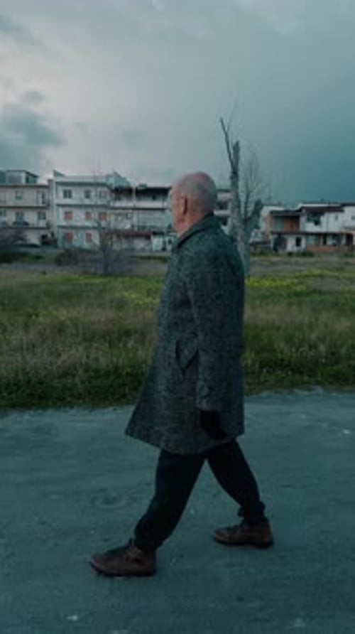 Elderly Man Walking in the Park on a Gloomy Cloudy Day in Winter