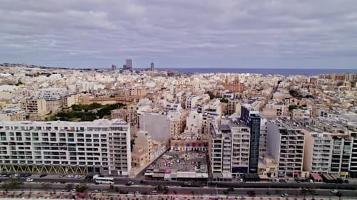 Aerial view of Sliema cityscapes in Malta. buildings and roads, pan left shot.