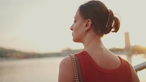 Close-up, girl stands on the seashore and looks at the bay