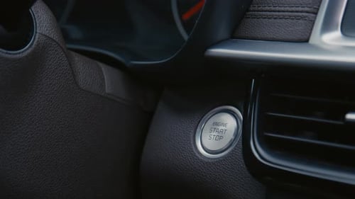 Drücken der Taste „Start Keyless Ignition System“ im Auto