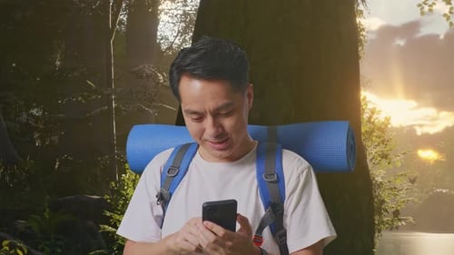 Close Up Of Asian Male Enjoy Using Smartphone While Exploring Nature