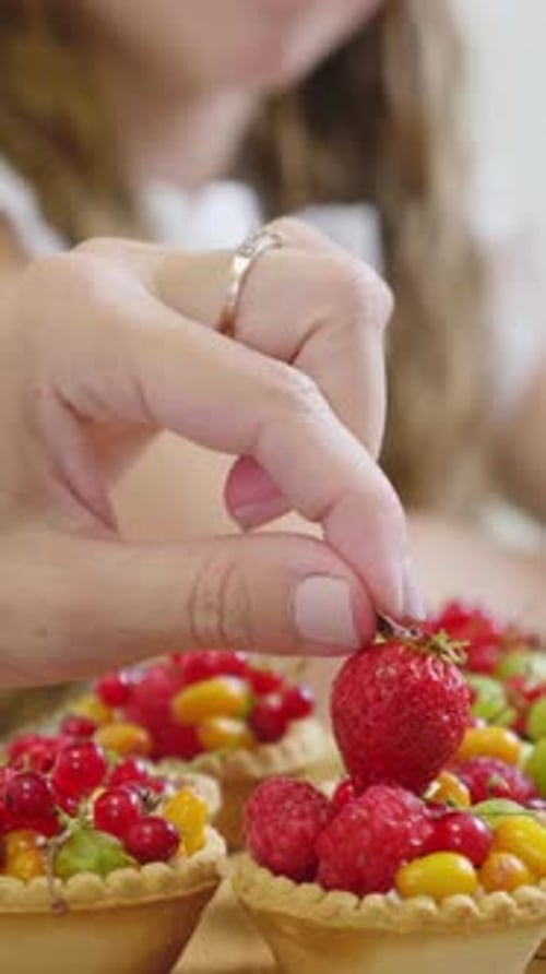 Delicious Fruit Tarts with Vibrant Berries and Colorful Candies on a Wooden Table