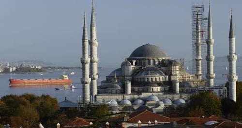 View of the Blue Mosque (Sultanahmet Camii) in Istanbul, Turkey with big cargo ship crossing the bos