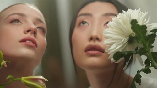 Two Young Women Pose with Flowers