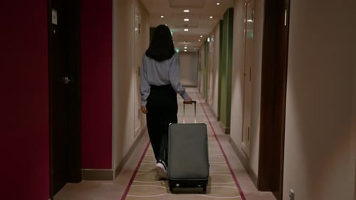 A girl with a suitcase walks down the corridor of a hotel businesswoman on trip the concept travel