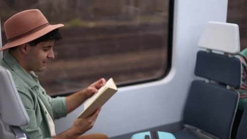 Man Reading Book on a Comfortable Train Journey