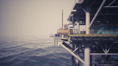 Oil Rig Surrounded By Ocean Waves at Dawn with Misty Atmosphere