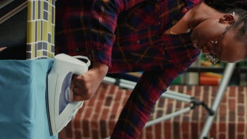 Woman Ironing Clothes in Her Home, Vertical