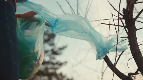Close Up Hands: una joven recoge basura en la bolsa de basura, ecosistema sucio, estilo de vida, basura