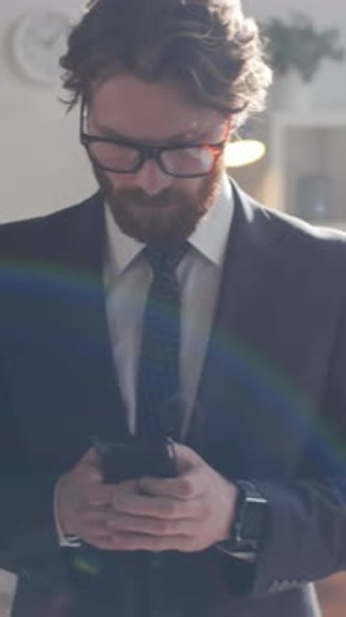 Businessman Texting on Mobile Phone during Workday in Office