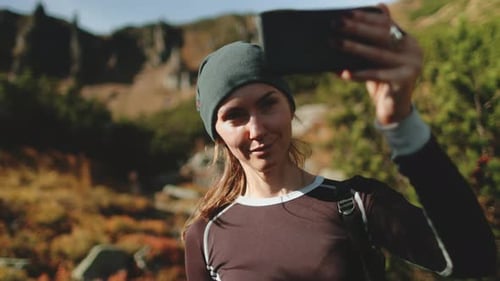Young Woman Capturing Vibrant Mountain Scene