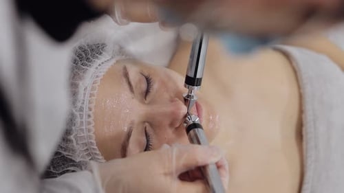 Beautician Doctor Makes Woman Micro Currents Face Therapy Using Electrical Impulses in Spa Salon